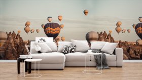 Un divano su sfondo di carta da parati fotografica che rappresenta delle mongolfiere